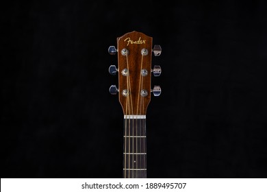 Kyiv, Ukraine: 01.08.2021: Fender acoustic guitar head with chrome tuning pegs and fretboard on isolated black background