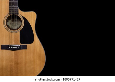 Kyiv, Ukraine - 01.12.2021:  
body part of classic yellow acoustic guitar Fender CD-60 with black pickguard on isolated black background with space for text