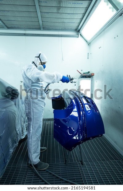 Kyiv, Ukraine - 02.02.2022: man painting a bumper
in the spray booth