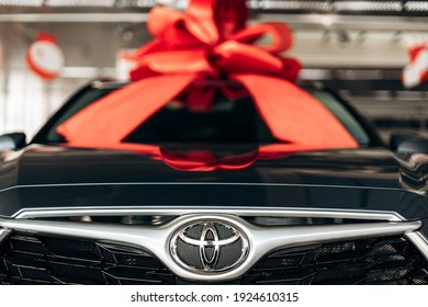 Kyiv, Ukraine - 09 Feb, 2021: Toyota car in the showroom. Toyota car with a red bow on the roof.