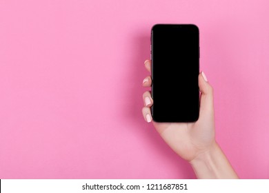 Kyiv, Ukraine, 2018-10-19. Top View Of A Woman Hand Using Iphone XS On Pink Background.