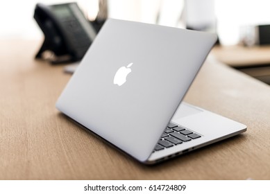 Kyiv, Ukraine - April 3th, 2017: Apple MacBook Pro 13 Laptop on wooden table and blurred background