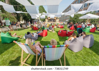 KYIV, UKRAINE - AUG 19: Many People Sitting In Shadows, Relaxing In Loungers On Grass During Popular Outdoor Street Food Festival On August 19, 2017. Kiev Is The 8th Most Populous City In Europe