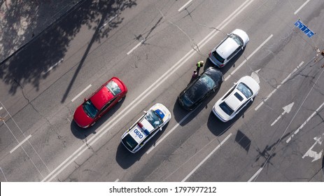 Kyiv, Ukraine - August 18, 2020: A police patrol arrives at the road car accident and Police officer listens to road accident participants. Drone Shot.