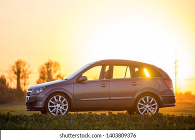 Kyiv, Ukraine - August 25, 2018: Car Parked In Countryside On Blurred Rural Landscape And Bright Orange Clear Sky At Sunset Copy Space Background. Transportation, Traveling, Vehicles Design Concept.