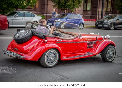 Kyiv, Ukraine - August 27, 2019: A Man Rides On The Street In A Red Retro Convertible. Open Top Car Old Vintage Model. Cars On The Road.