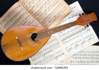 Kyiv, Ukraine - Circa 2016: Vintage Mandolin On A Background Of Open Sheet Music Book.