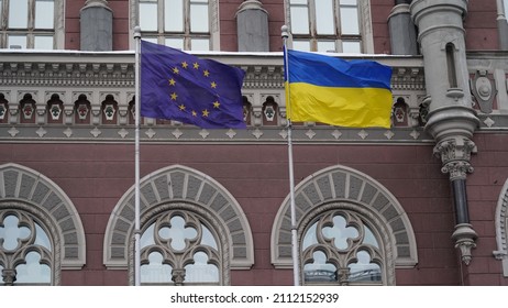 KYIV, UKRAINE - DECEMBER 10, 202: The European Union flag and the Ukrainian flag are waving on the flagpole near the National Bank of Ukraine.
