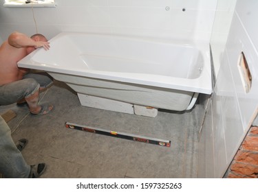 KYIV, UKRAINE - December, 21, 2019:  Contractors installing bathtub in house bath room
