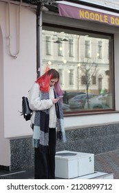 Kyiv, Ukraine - February 9 2022: Woman With Dyed Hair Standing On Street An Looking At Phone