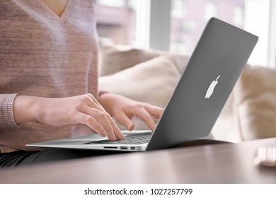 KYIV, UKRAINE - JANUARY 10, 2018: Woman Using Apple Macbook Air Silver, Indoors