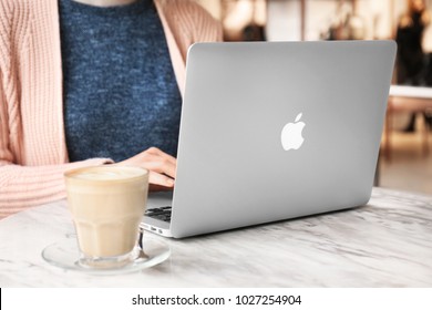 KYIV, UKRAINE - JANUARY 15, 2018: Woman Using Apple Macbook Air At Table