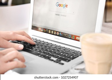 KYIV, UKRAINE - JANUARY 15, 2018: Woman Using Apple Macbook Air With Google Search Page On Screen At Table In Cafe