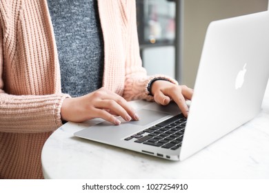 KYIV, UKRAINE - JANUARY 15, 2018: Woman Using Apple Macbook Air At Table