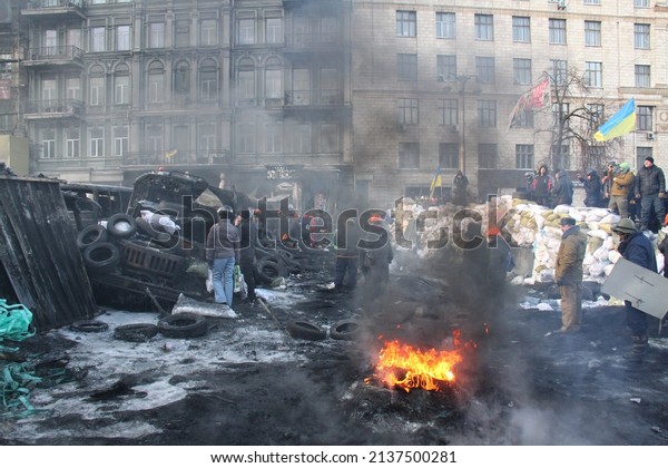 Kyiv, Ukraine - January 24 2014: Riots in the\
city. Citizens in conflict with the power. Protesters harness tires\
and vehicles. Police disperse demonstrators. People fighting for\
their rights.