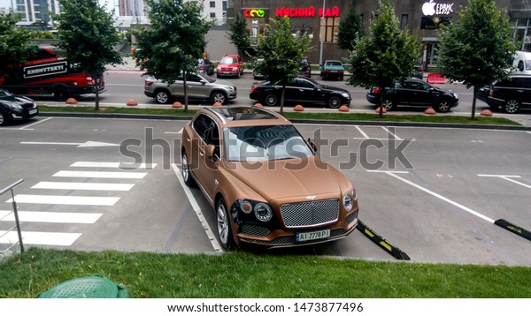 Kyiv Ukraine - July 05, 2019: True modern cityscape\
of the Ukrainian capital with expensive cars on the street. Luxury\
avtomotive desigh of contemporary stylish supercar. Real urban\
style of rich man.