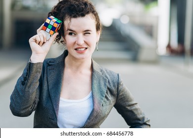 Kyiv, Ukraine - July 21th, 2017: Business woman plaing with the Rubik's Cube. Rubik's cube invented by a Hungarian architect Erno Rubik in 1974.