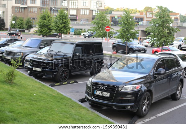 Kyiv Ukraine - July 25, 2019: True modern cityscape\
of the Ukrainian capital with expensive cars on the street. Luxury\
avtomotive desigh of contemporary stylish supercar. Real urban\
style of rich man.