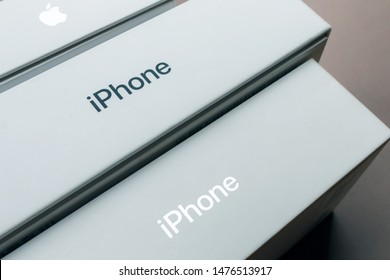KYIV, UKRAINE - July 30, 2019: gray iphone logo on a new apple retail boxes close-up, brown background. a row with boxes with iphone хs max and air pods 