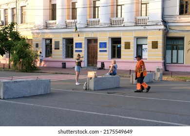 Kyiv, Ukraine - July 5 2022: People On A Square In Historic Center Of Downtown; Worker In Orange Uniform Walking Past Two Women Taking Photo