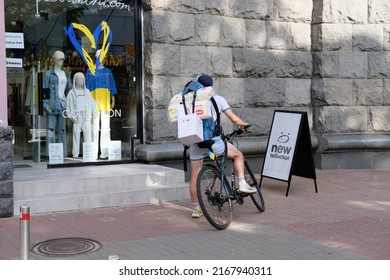 Kyiv, Ukraine - June 15 2022: Man On A Bicycle Standing In Front Of A Store Window Display