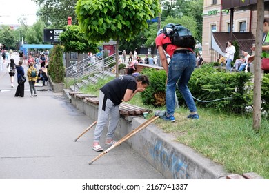 Kyiv, Ukraine - June 15 2022: Woman Washing Face From Water Hose On A Sidewalk