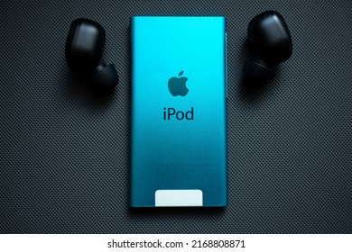 KYIV, UKRAINE - JUNE 15, 2022: Apple IPod Nano 7 Gen With Headphones On A Gray Background