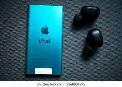 KYIV, UKRAINE - JUNE 15, 2022: Apple IPod Nano 7 Gen With Headphones On A Gray Background