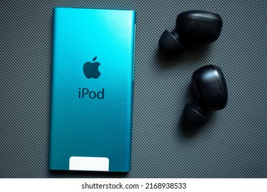 KYIV, UKRAINE - JUNE 15, 2022: Apple IPod Nano 7 Gen With Headphones On A Gray Background