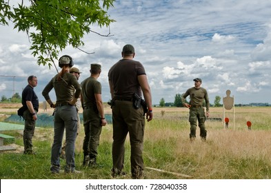 KYIV, UKRAINE - JUNE 17 2017: The civil men and a woman are trained by the coach at the outdoor shooting range during "Open Gun Day". KYIV, UKRAINE - JUNE 17 2017.