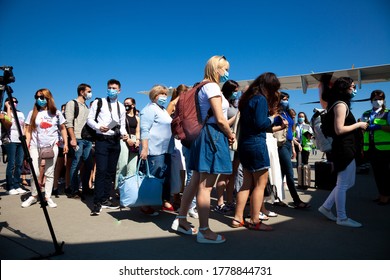 Kyiv, Ukraine - June 27, 2020: Passengers Board The Plane. Masked People Board The Flight. Airport Boryspil, Windrose Airlines Plane. Runway. Travel During Quarantine. A Passenger In Mask.