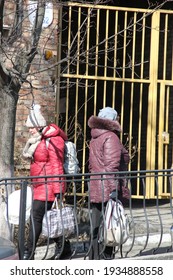 Kyiv, Ukraine - March 11 2021: Two Women With Heavy Bags Walking In Opposite Directions