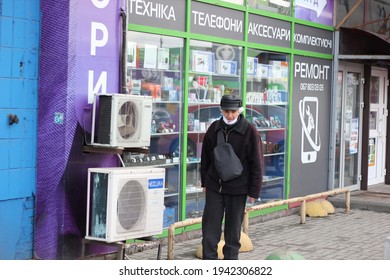 Kyiv, Ukraine - March 11 2021: Elderly Man Walks Past The Electronics Store Window Display