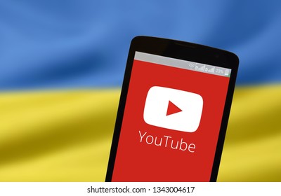KYIV, UKRAINE - MARCH 19, 2019: The image of the logo of Youtube in the phone screen on the background of the flag of Ukraine
