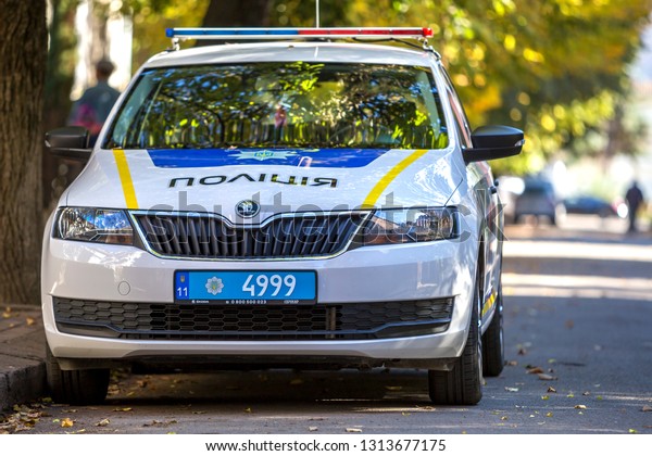 KYIV, UKRAINE - March 30, 2018:\
Ukrainian white police car cruiser with emergency lights parked on\
sunny summer street. Security and control in modern\
life.