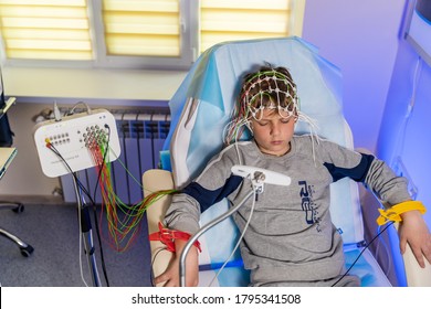 KYIV, UKRAINE - May 2020: Boy in a special cap during electroencephalography next to the monitor with readings.
