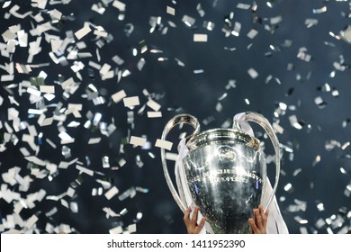 KYIV, UKRAINE – MAY 26, 2018: Champions League cup in the hands of the winner, confetti on the background. UEFA Champions League final between Real Madrid and Liverpool. NSC Olympic stadium in Kyiv.
