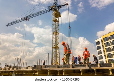 Kyiv, Ukraine - May 3, 2019: Workers working on concrete frame of tall apartment building under construction in a city.