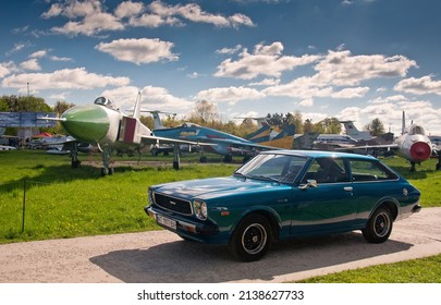 Kyiv, Ukraine - May 7, 2021: Blue old classic retro car Corolla E30 Liftback 1977 against the backdrop of an old plane. It was the third generation of cars sold by Toyota under the Corolla nameplate.
