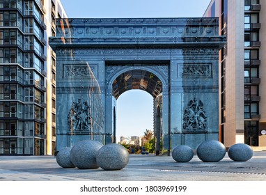 Kyiv, Ukraine, a modern stylized triumphal arch reminiscent of the famous Arc de Triomphe in Paris, located in the French quarter of Kyiv. Stone granite balls in the foreground, drawing on the facade.