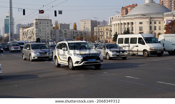 Kyiv, Ukraine - November\
1, 2021. A police car illuminated by the counter sun is driving\
along the main street of the capital. Police work in the city.\
Policemen on patrol.