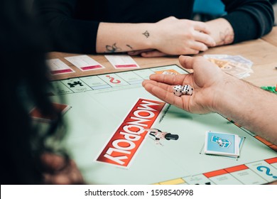 KYIV, UKRAINE - NOVEMBER 15, 2019: Cropped View Of Man And Women Playing In Monopoly At Table