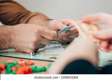 KYIV, UKRAINE - NOVEMBER 15, 2019: Selective Focus Of Man And Woman Playing Monopoly Game 