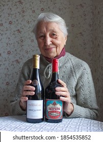 Kyiv, Ukraine - November 15, 2020: The Old Woman With Bottles Of Red Dry Wine From Cabernet, Garnacha And Syrah From Cotes Du Rhone, France, 2018