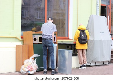 Kyiv, Ukraine - November 21 2021: McDonald's Employee Cleaning Garbage Bins Outside The Restaurant