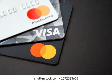 KYIV, UKRAINE - NOVEMBER 6, 2019: Credit and debit cards Visa and Mastercard for cashless payments on a black matte surface