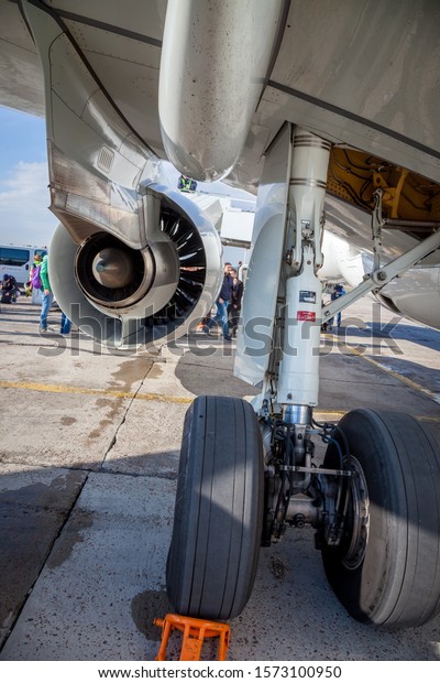 Kyiv, Ukraine - October 29,\
2019: The landing gear and flaps of the aircraft Embraer E190-E2\
passenger plane.   A shoe under the wheel is a stopper for\
transport.