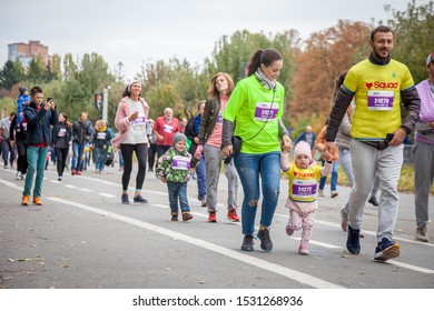 Kyiv, Ukraine - October 5, 2019. Running People - The Family Run. Runners Dad, Mom, Baby, Kids. Run Of The Competition As Part Of The Marathon.