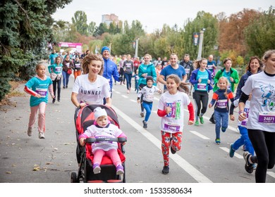 Kyiv, Ukraine - October 5, 2019: A Woman Is Running With A Stroller. Family Run. Street Competitions In The Marathon. Running People. Mom Runner With A Pram Running.