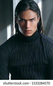 KYIV, UKRAINE - Sep 30, 2019: A vertical closeup shot of a green-eyed young male with dark hair posing for a fashion photoshoot